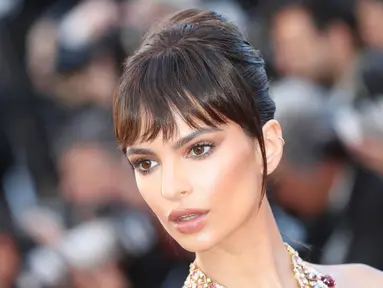 Ekspresi Emily Ratajkowski saat menghadiri pembukaan Festival Film Cannes ke-70 di Cannes, Prancis (17/5). Mengenakan gaun berwarna kream  Emily Ratajkowski saat melintas di karpet merah. (AFP Photo/Valery Hache)