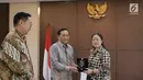 Direktur Utama Indosiar Imam Sudjarwo (tengah) memberikan cenderamata kepada Menko PMK Puan Maharani saat kunjungan ke kantor Kemenko PMK, Jakarta, Selasa (19/2). (Liputan6.com/Herman Zakharia)