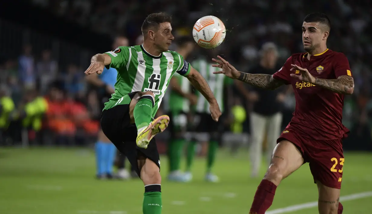 Gelandang Real Betis Joaquin berebut bola dengan bek AS Roma Gianluca Mancini  pada laga pekan ke-4 Grup C Liga Europa 2022/2023  di Estadio Benito Villamarin, Kamis (13/10/2022). Kedua tim saling berbalas serangan, dan menciptakan banyak peluang. (Photo by CRISTINA QUICLER / AFP)