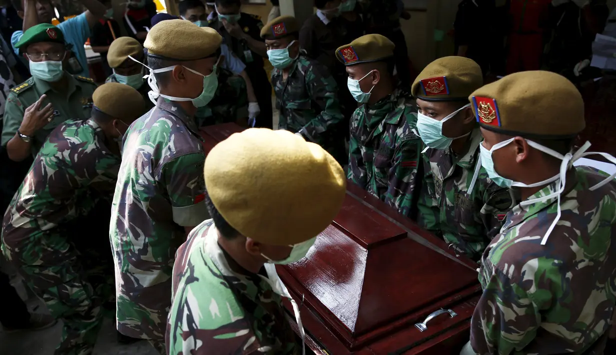 Anggota TNI membawa peti mati korban dari jatuhnya pesawat Hercules C-130 di Medan, Rabu (1/7/2015). Peristiwa ini menambah catatan kecelakaan yang disebabkan tuanya alustista yang digunakan TNI. (REUTERS/Beawiharta)