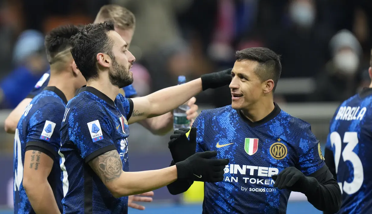 Penyerang Inter Milan Alexis Sanchez (kanan) memberi selamat kepada Hakan Calhanoglu yang mencetak gol ketiga timnya ke gawang Cagliari pada laga lanjutan Liga Italia pekan ke-17 di Guseppe Meazza, Senin dini hari WIB (13/12/2021). Inter Milan menang telak 4-0 atas Cagliari. (AP Photo/Luca Bruno)