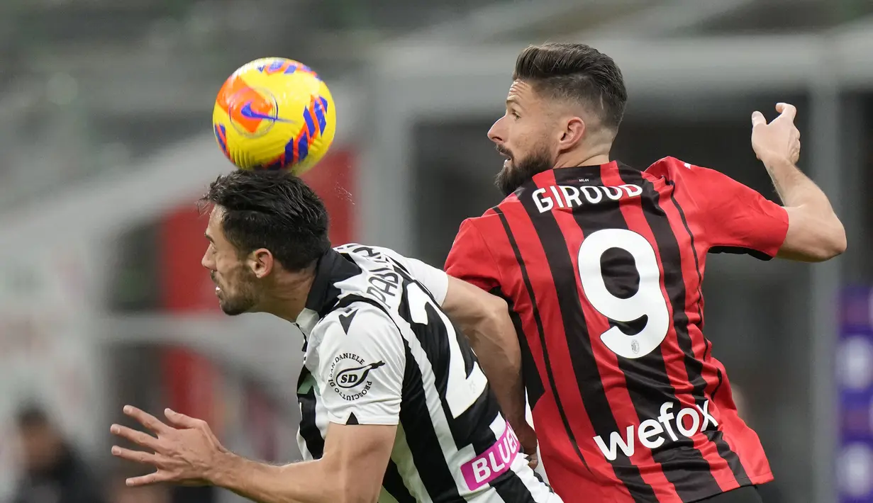 Penyerang AC Milan, Olivier Giroud berebut bola dengan pemain Udinese, Pablo Mari pada pertandingan lanjutan Liga Serie A Italia di stadion San Siro di Milan, Italia, Sabtu (26/2/2022). AC Milan bermain dengan Udinese 1-1. (AP Photo/Luca Bruno)