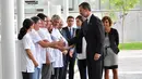 Para petugas dan staf menyambut kedatangan Raja Spanyol Felipe VI dan istrinya Ratu Letizia di Rumah Sakit Mar de Barcelona, Sabtu (19/8). Pasangan kerajaan tersebut mengunjungi rumah sakit guna menjenguk korban serangan teror Barcelona. (CASA REAL/AFP)