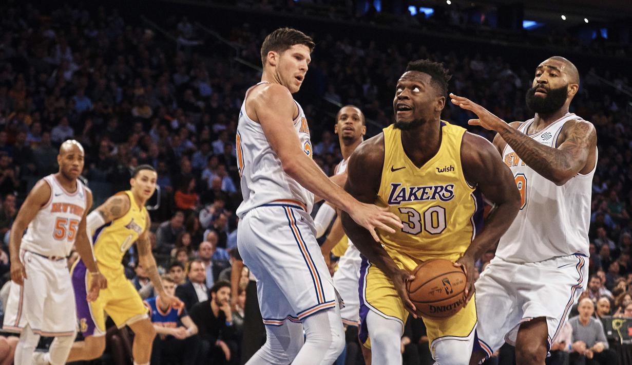 Aksi pemin Los Angeles Lakers, Julius Randle (tengah) menerobos pertahanan New York Knicks pada lanjutan NBA basketball game di Madison Square Garden, New York, (12/12/2017). knicks menang 113-109. (AP/Andres Kudacki)