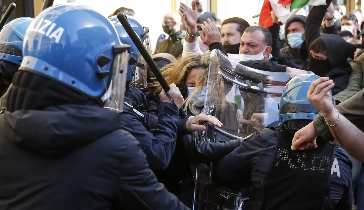 Demonstran berkelahi dengan polisi anti huru-hara di luar lower Chamber saat aksi protes pemilik restoran dan bisnis lainnya di Roma, Selasa (6/4/202). Mereka menuntut pembukaan kembali bisnis dan memprotes tindakan pembatasan untuk mengatasi lonjakan kasus COVID-19 (Cecilia Fabiano/Lapresse Via AP)