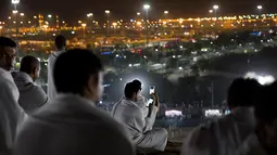 Jemaah calon haji mengabadikan gambar saat berada di Bukit Jabal Rahmah di luar kota suci Mekah, Arab Saudi (30/8).  Bukit Jabal Rahmah dikenal sebagai bukit kasih sayang. (AP Photo / Khalil Hamra)