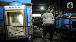 Pekerja mengangkut kerupuk untuk digoreng di industri rumahan kawasan Cipinang Melayu, Jakarta, Selasa (16/2/2021). Selama pandemi corona, jumlah produksi di industri rumahan ini dikurangi dari 10.000 kerupuk per hari, kini hanya 5.000 kerupuk tiap harinya (merdeka.com/Iqbal S Nugroho)