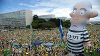 Kubu oposisi membawa balon raksasa dalam unjuk rasa menuntut pengunduran diri Presiden Dilma Rousseff di Esplanada dos Ministerios, Brasil, Minggu (13/3). (Andressa Anholete / AFP)