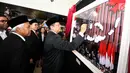 Ketua DPR Bambang Soesatyo menandantangani sebuah foto selama pameran Foto Wartawan Parlemen bertema DPR Zaman Now di Jakarta, Kamis (29/8/2019).  Pameran ini berlangsung 28 Agustus-2 September 2019. (Liputan6.com/Johan Tallo)