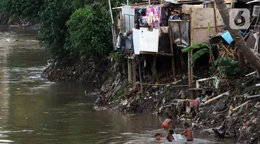 Anak-anak bermain di bantaran sungai Ciliwung, Pemukimannya, Manggarai, Jakarta, Selasa (29/9/2020). Irjen Kemenkeu Sumiyati mengatakan Pengangguran dan juga angka kemiskinan diperkirakan akan naik cukup signifikan. (Liputan6.com/Johan Tallo)