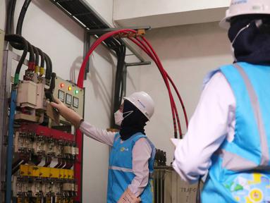 Petugas wanita PLN UID Jakarta Raya melakukan pengecekan gardu distribusi listrik di jalan M.H Tamrin, Jakarta, Rabu (20/4/2022). PLN juga memastikan pasokan listrik aman selama Ramadhan dan Idul Fitri. (Liputan6.com/Angga Yuniar)