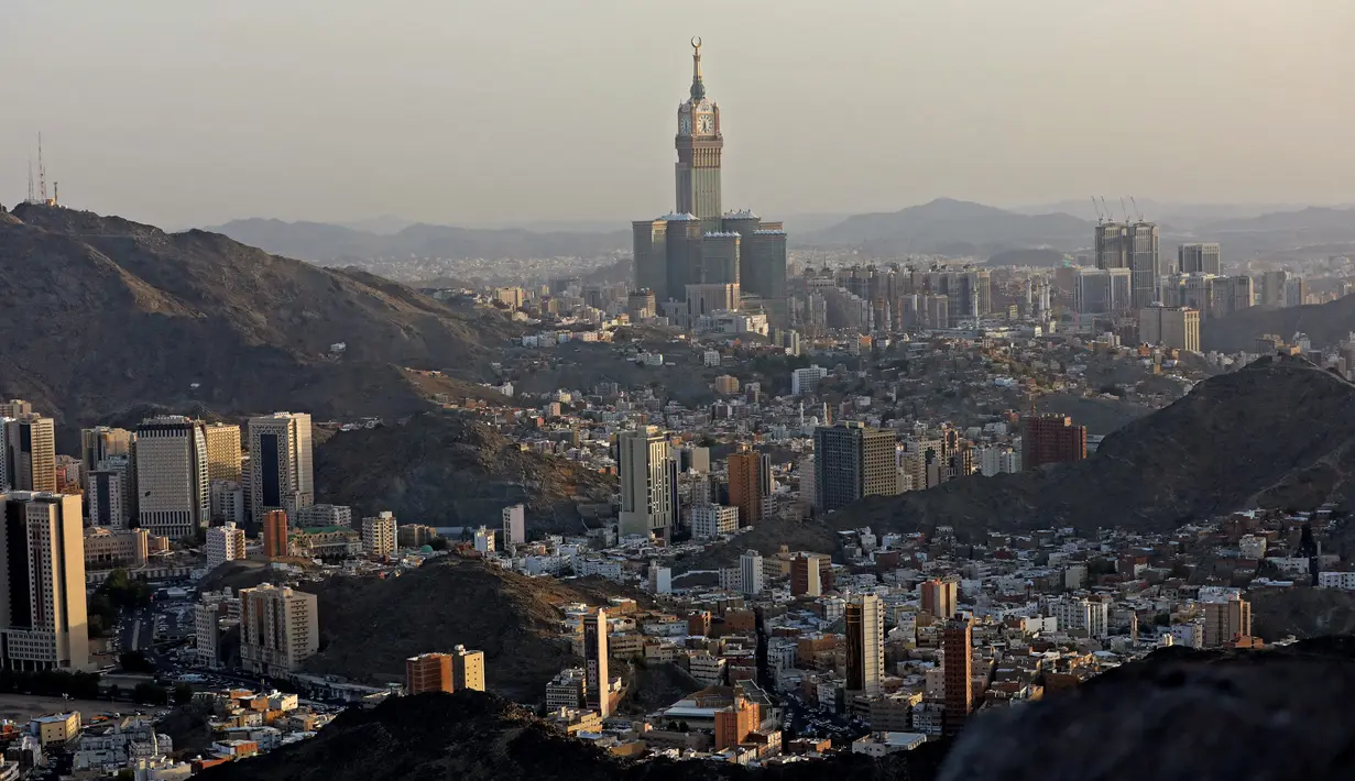 Menara Abraj Al-Bait juga dikenal sebagai Mekah Royal Hotel Clock Tower terlihat dari Jabal al-Noor atau Gunung Cahaya yang menghadap ke Kota Suci Mekkah, Arab Saudi, 5 Juli 2022. Satu juta orang, termasuk 850 ribu dari luar negeri, diizinkan untuk berpartisipasi dalam haji tahun ini setelah dua tahun terakhir jumlahnya dikurangi secara drastis karena pandemi virus corona COVID-19. (Christina ASSI/AFP)