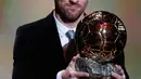 Pemain Barcelona Lionel Messi memegang trofi Ballon d'Or 2019 di Chatelet Theatre, Paris, Prancis, Senin (2/12/2019). Messi mengukir sejarah dengan memenangkan Ballon d'Or untuk keenam kalinya. (AP Photo/Francois Mori)