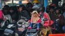 Seorang anak duduk di atas motor saat menanti waktu masuk kapal penyebrangan di Dermaga 1 Pelabuhan Penyebrangan Merak, Banten, Sabtu (1/6/2019). Meski berbahaya, pemudik tetap nekat membawa anak berkendara sepeda motor menuju kampong halaman. (Liputan6.com/Helmi Fithriansyah)