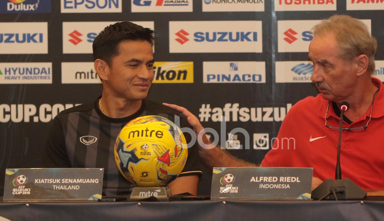 Pelatih  Timnas Indonesia, Alfred Riedl, menepuk bahu pelatih Thailand, Kiatisuk Senamuang, saat konferensi pers di Hotel Aston, Sentul. (13/12/2016). (Bola.com/Nicklas Hanoatubun)