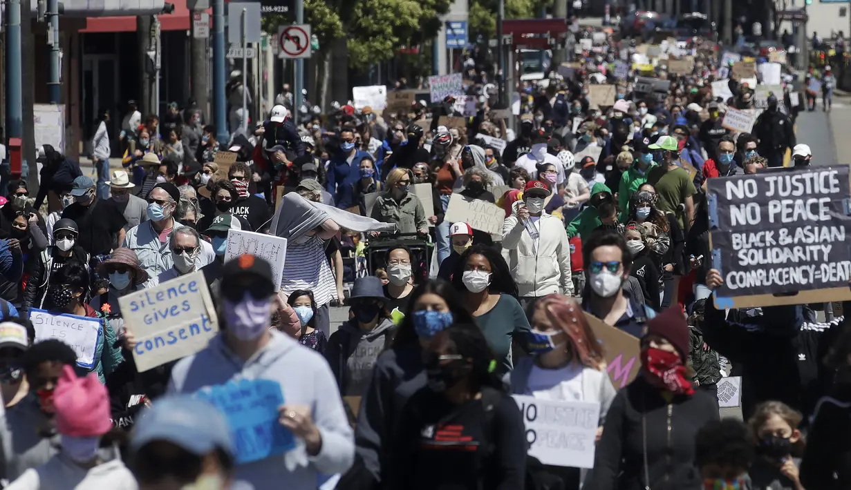 Pengunjuk rasa yang memprotes kematian George Floyd berbaris di Ocean Avenue, San Francisco, Amerika Serikat, Minggu (7/6/2020). Gelombang protes atas kematian George Floyd terus mengguncang Amerika Serikat. (AP Photo/Jeff Chiu)