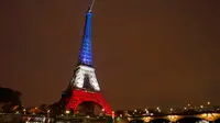 Menara Eiffel pada Senin (16/11), dihiasi lampu berwarna bendera Prancis untuk menghormati para korban serangan teror di Paris hari Jumat (13/11) lalu. Menara Eiffel dan sejumlah tempat kebudayaan sempat ditutup selama dua hari. (REUTERS/Benoit Tessier)