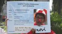 Seorang pria berpose dengan papan mirip E-KTP di CFD, Jakarta, Minggu (19/3). Aktivis Gerakan Sapu Koruptor menuntut Jokowi untuk menonaktifkan pejabat yang terlibat korupsi E-KTP. (Liputan6.com/Angga Yuniar) 