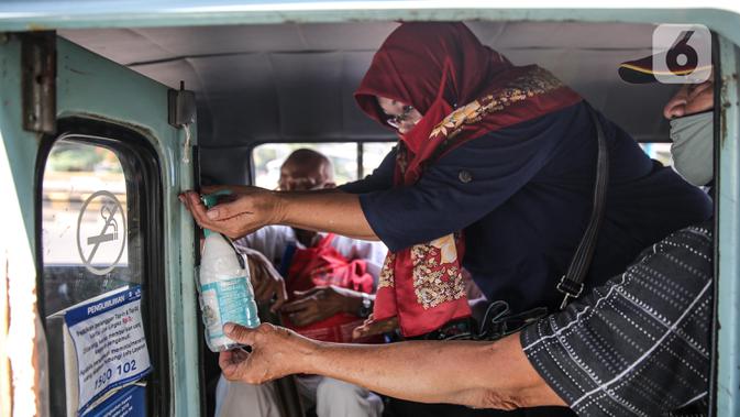 Penumpang menggunakan cairan pembersih tangan saat menaiki angkutan umum Jak Lingko di kawasan Cawang, Jakarta, Senin (6/7/2020). Pada perpanjangan masa PSBB transisi, angkutan umum sudah mulai beroperasi kembali dengan menerapkan protokol Kesehatan Covid-19. (Liputan6.com/Faizal Fanani)
