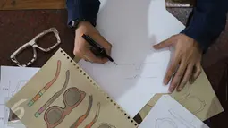 Pemilik brand kacamata kayu Kabau Bonny Andrew sedang mensketsa kacamata di studio Namines, Jakarta, Kamis (18/08). Kacamata kabau bisa di pesan dengan sesuai permintaan yang jadi selama 1 minggu. (Liputan6.com/Herman Zakharia)
