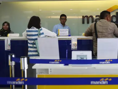 Nasabah melakukan transaksi di cabang Bank Mandiri Pertamina UPMS III, Jakarta, Rabu (28/6). Bank Mandiri memberikan layanan perbankan terbatas kepada nasabah secara bergantian pada musim liburan Idul Fitri 26-30 Juni 2017. (Liputan6.com/Angga Yuniar)