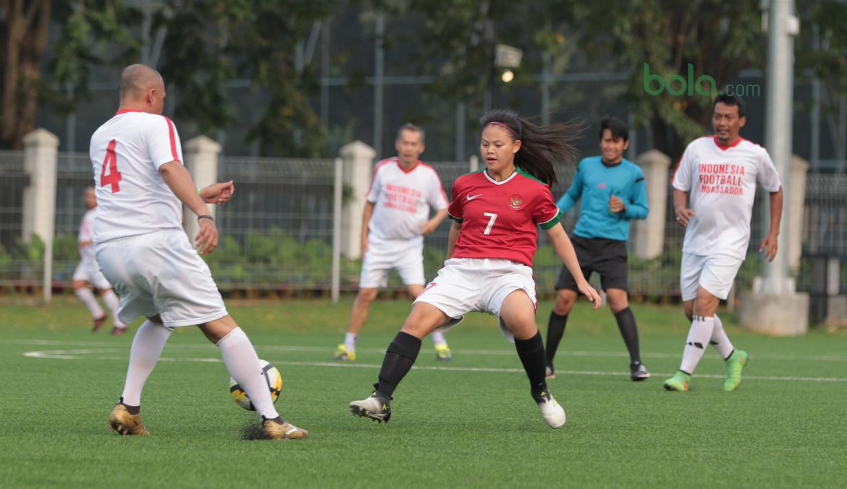 Pemain Timnas Wanita Indonesia, Dhanielle Daphne (tengah) mencoba menghalangi gerakan pemain Legenda Indonesia pada laga uji coba di Lapangan ABC Senayan, Jakarta, Kamis (5/4/2018). Timnas Wanita Indonesia menang 3-2. (Bola.com/Nick Hanoatubun)