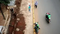 Warga melintas di sisi proyek pembangunan trotoar Jalan Raya Kalibata, Jakarta, Rabu (2/11). Pembangunan penataan trotoar di kawasan Jalan Raya Kalibata, Jakarta Selatan baru mencapai 15 persen. (Liputan6.com/Helmi Fithriansyah)