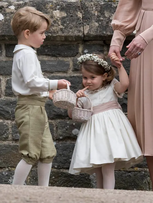 Penampilan Pangeran George dan Putri Charlotte saat menjadi pengiring pengantin Pippa Middleton dan  James Matthews, di Gereja St. Mark, Sabtu (20/5). George dan Charlotte tampil menggemaskan berbalut busana Pepa & Co. (AP Photo/Kirsty Wigglesworth, Pool)
