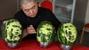 Seorang guru sekolah menengah mengukir wajah pemain sepak bola Prancis, Antoine Griezmann (tengah) pada buah semangka di Shenyang, Provinsi Liaoning, China, Senin (9/7). (AFP)