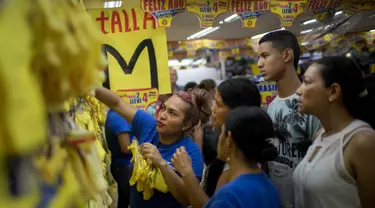 Seorang wanita memilih celana dalam berwarna kuning di Medellin, Kolombia, Jumat (29/12). Di Kolombia, tradisi mengenakan celana dalam berwarna kuning saat malam Tahun Baru dianggap dapat membawa kemakmuran dan keberuntungan. (Joaquin SARMIENTO / AFP)