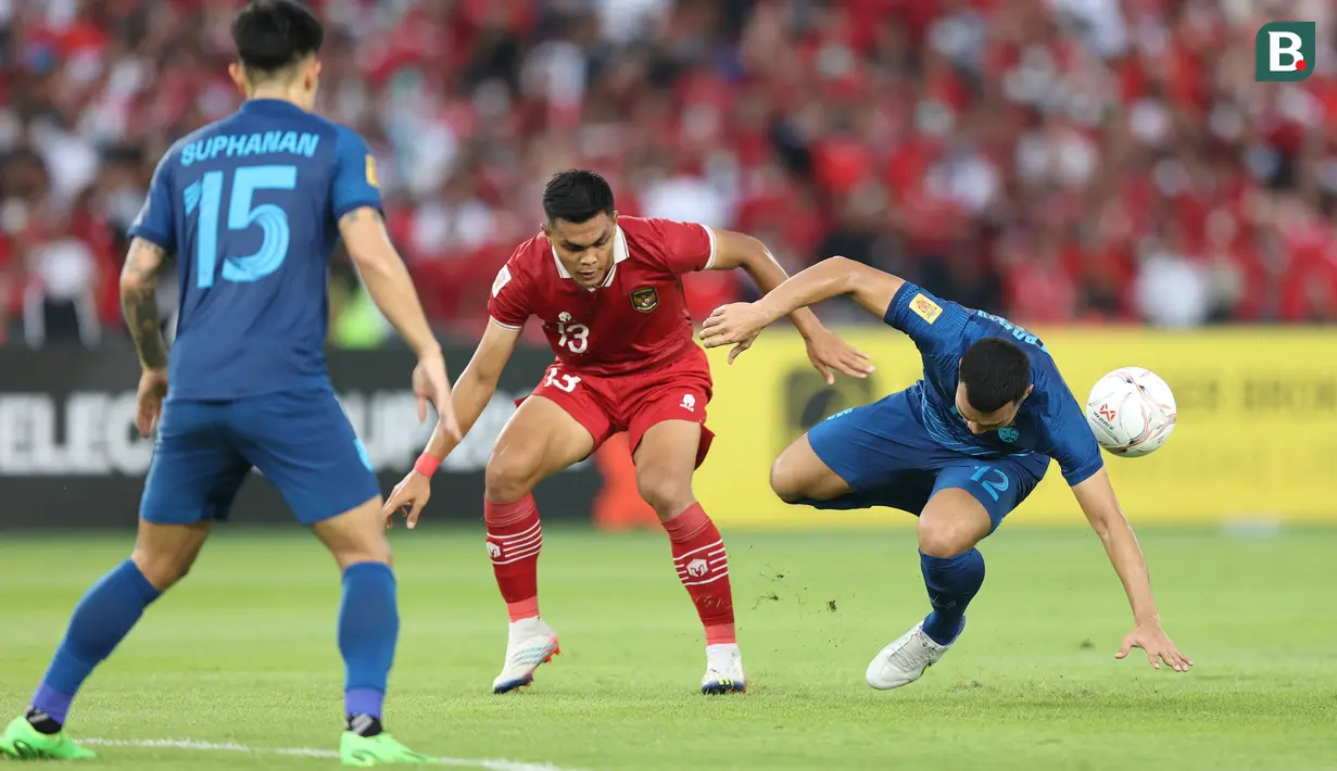Pemain Timnas Indonesia, Rachmat Irianto (tengah) berebut bola dengan pemain Thailand, Kritsada Kaman dalam laga matchday ketiga Grup A Piala AFF 2022 di Stadion Utama Gelora Bung Karno, Senayan, Jakarta, Kamis (29/12/2022) sore WIB. (Bola.com/Bagaskara Lazuardi)
