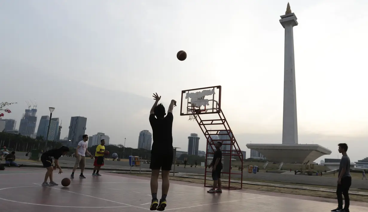 Sejumlah warga bermain basket di kawasan Monas, Jakarta, Jumat (11/10). Kawasan Monas menjadi pilihan warga Jakarta dan pekerja ibu kota untuk berolahraga sore. (Bola.com/Yoppy Renato)