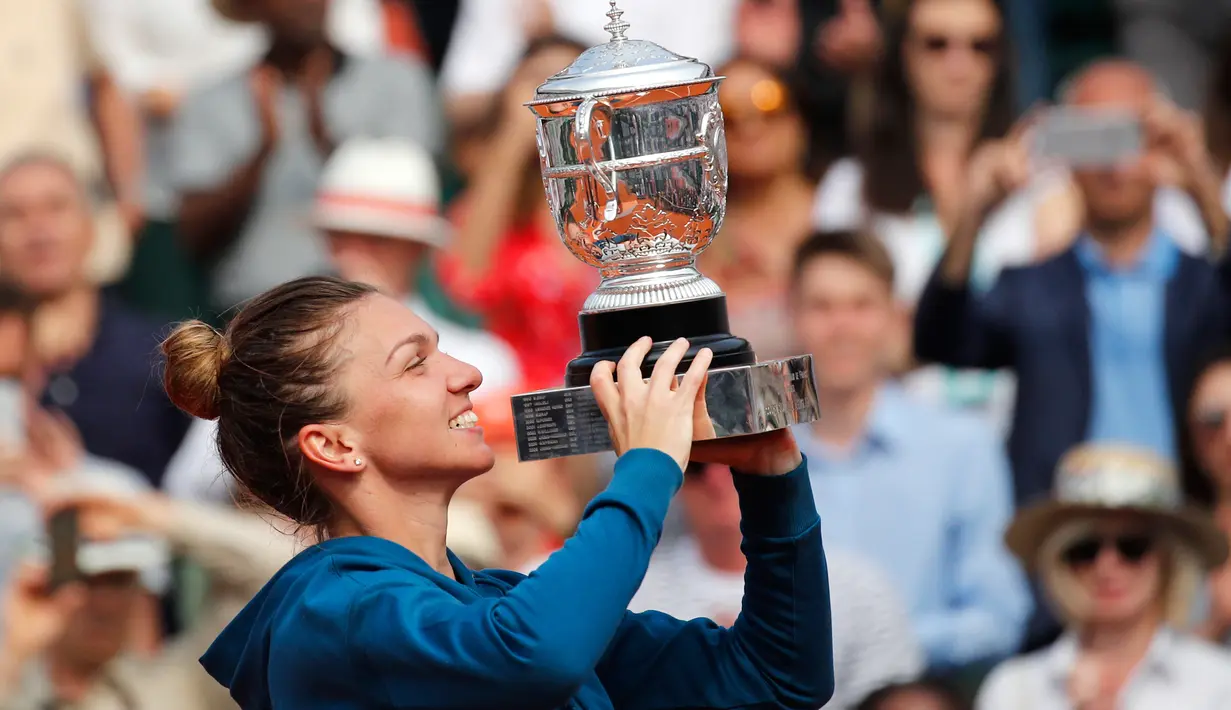 Petenis Rumania, Simona Halep mengangkat trofi Grand Slam seusai menang atas petenis AS, Sloane Stephens pada babak final Prancis Terbuka 2018 di stadion Roland Garros, Sabtu (9/6). Halep berhasil meraih gelar grand slam pertamanya. (AP/Christophe Ena)