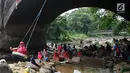 Seorang anak bermain ayunan di kolong jembatan Sempur, Bogor (16/9). Musim kemarau yang menyebabkan debit Sungai Ciliwung menyusut drastis dimanfaatkan warga Bogor dan sekitarnya untuk berwisata murah dan gratis di aliran sungai. (Merdeka.com/Arie Basuki)