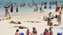 Orang-orang berkumpul di Pantai Bondi saat merayakan Natal di Sydney, Sabtu (25/12/2021). (AP Photo/Rick Rycroft)