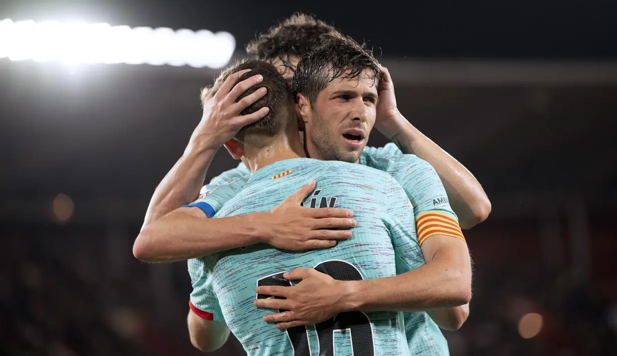 Gelandang Barcelona #16 Fermin Lopez diberi ucapan selamat oleh #20 Sergi Roberto setelah mencetak gol kedua timnya ke gawang Almeria pada laga jornada 36 La Liga 2023/2024 di Power Horse Stadium, Jumat (17/5/2024) dini hari WIB. (JORGE GUERRERO / AFP)