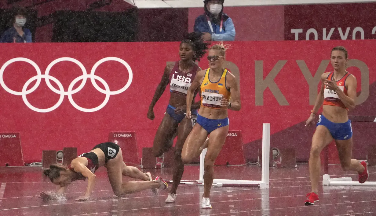 Sara Petersen (kiri) dari Denmark terjatuh saat Femke Bol (kanan) dari Belanda berlomba untuk memenangkan perlombaan lari gawang 400 meter putri Olimpiade Tokyo 2020 di Tokyo, Jepang, Senin (2/8/2021). (AP Photo/Charlie Riedel)