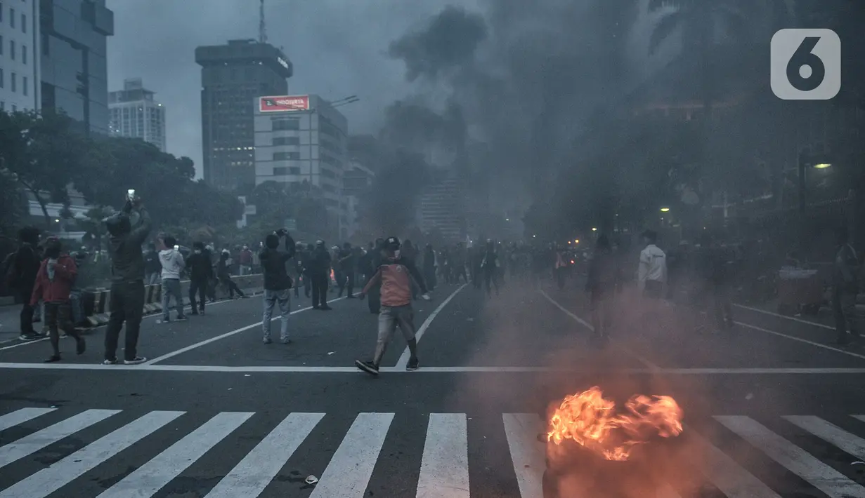 Kepulan asap menyelimuti massa saat aksi menolak UU Omnihus Law Cipta Kerja di kawasan Patung Kuda, Jakarta, Selasa (20/10/2020). (merdeka.com/Iqbal S. Nugroho)