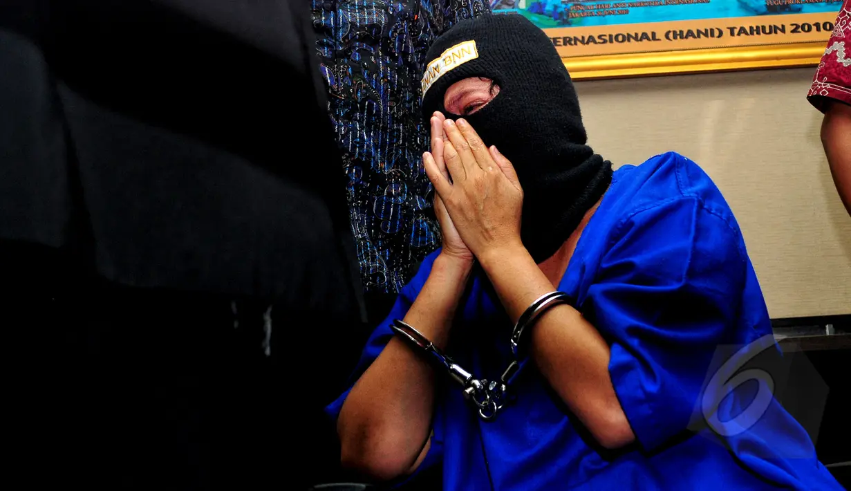 SA (45) tampak menangis di hadapan petugas di Kantor BNN, Jakarta, Selasa (19/5/2015). SA dan AN, yang diduga menjadi kurir, ditangkap aparat BNN dengan barang bukti 12,29 kilogram sabu. (Liputan6.com/Yoppy Renato)