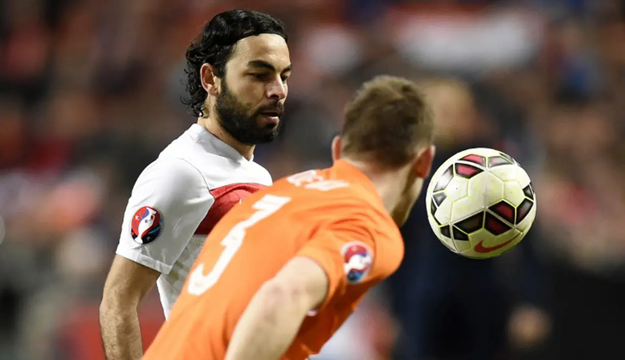 Gelandang Turki, Selcuk Inan (kiri) berebut bola udara dengan bek belanda stefan de vrij saat kualifikasi Piala Eropa 2016 di Amsterdam Arena, Minggu (29/3/2015). Belanda bermain imbang 1-1 melawan turki. (AFP PHOTO/John Thys)