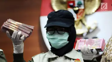 Petugas KPK menunjukkan barang bukti hasil OTT Bupati Nganjuk Taufiqurrahman saat rilis di Gedung KPK, Jakarta, Kamis (26/10). KPK menyita uang Rp 298.020.000,- dan menetapkan lima orang tersangka. (Liputan6.com/Helmi Fithriansyah)