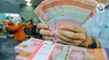 Pegawai menunjukkan mata uang rupiah di salah satu gerai penukaran mata uang di Jakarta, Kamis (5/1/2023). Nilai tukar rupiah ditutup di level Rp15.616 per dolar AS pada Kamis (5/1) sore ini. Mata uang Garuda melemah 34 poin atau minus 0,22 persen dari perdagangan sebelumnya. (Liputan6.com/Angga Yuniar)