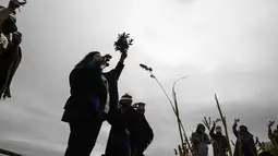 Masyarakat Adat Mapuche mengambil bagian dalam ritual selama gerhana matahari total di Carahue, La Araucania, Chile, Senin (14/12/2020). Gerhana matahari total terlihat dari Chile dan wilayah Patagonia utara Argentina. (AP Photo/Esteban Felix)