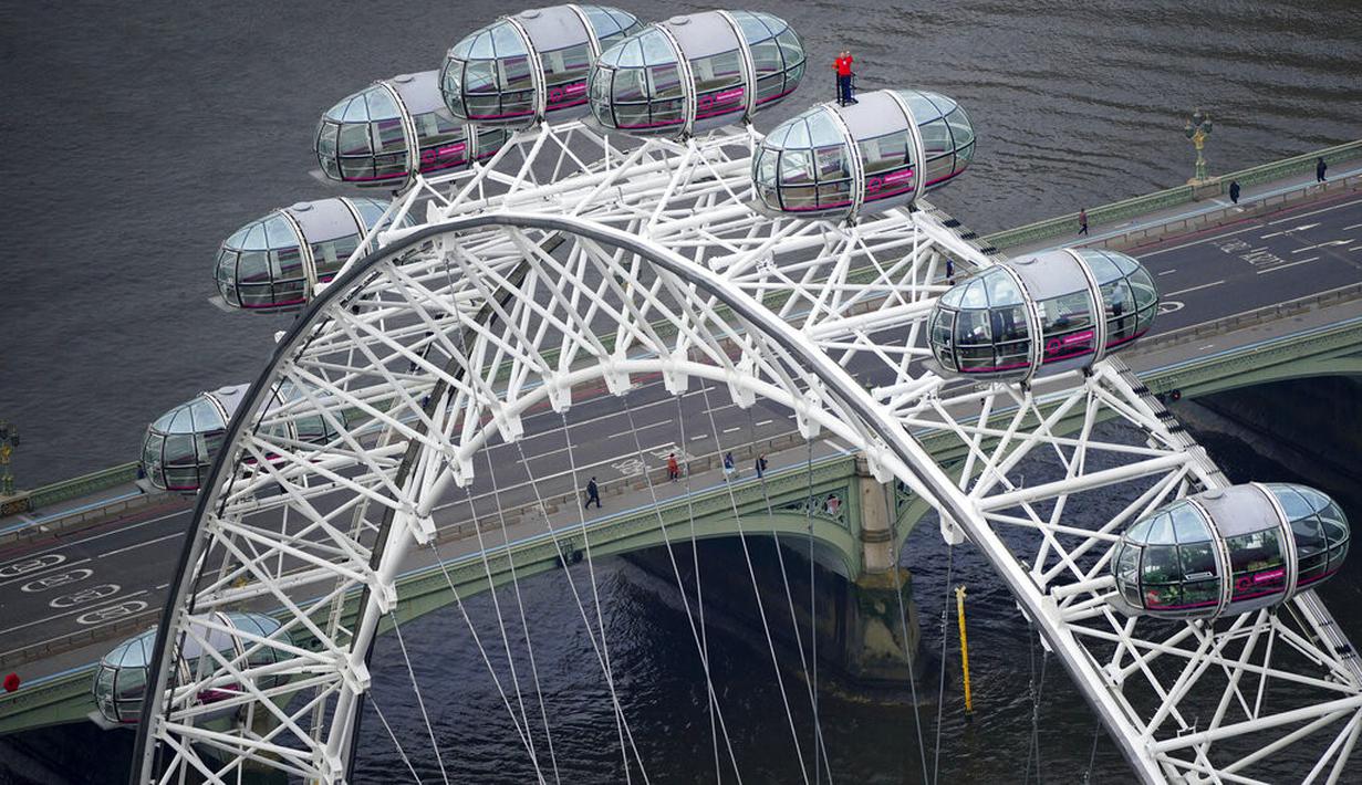 Legenda Inggris yang berjaya di Piala Dunia 1966 Geoff Hurst berdiri di atas pod komedi putar London Eye memandang ke arah Stadion Wembley di London (9/7/2021). Geoff Hurst tampil mengenakan jersey Inggris di final Piala Dunia 1966. (Dominic Lipinski/PA via AP)