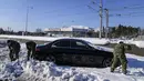 Tentara Yunani berusaha membebaskan kendaraan yang terjebak salju di jalan raya Attiki Odos, menyusul hujan salju lebat pada Selasa, di Athena, Rabu (26/1/2022). Upaya tersebut dilakukan ketika pihak berwenang berusaha membersihkan jalan yang terblokir. (AP/Thanassis Stavrakis)