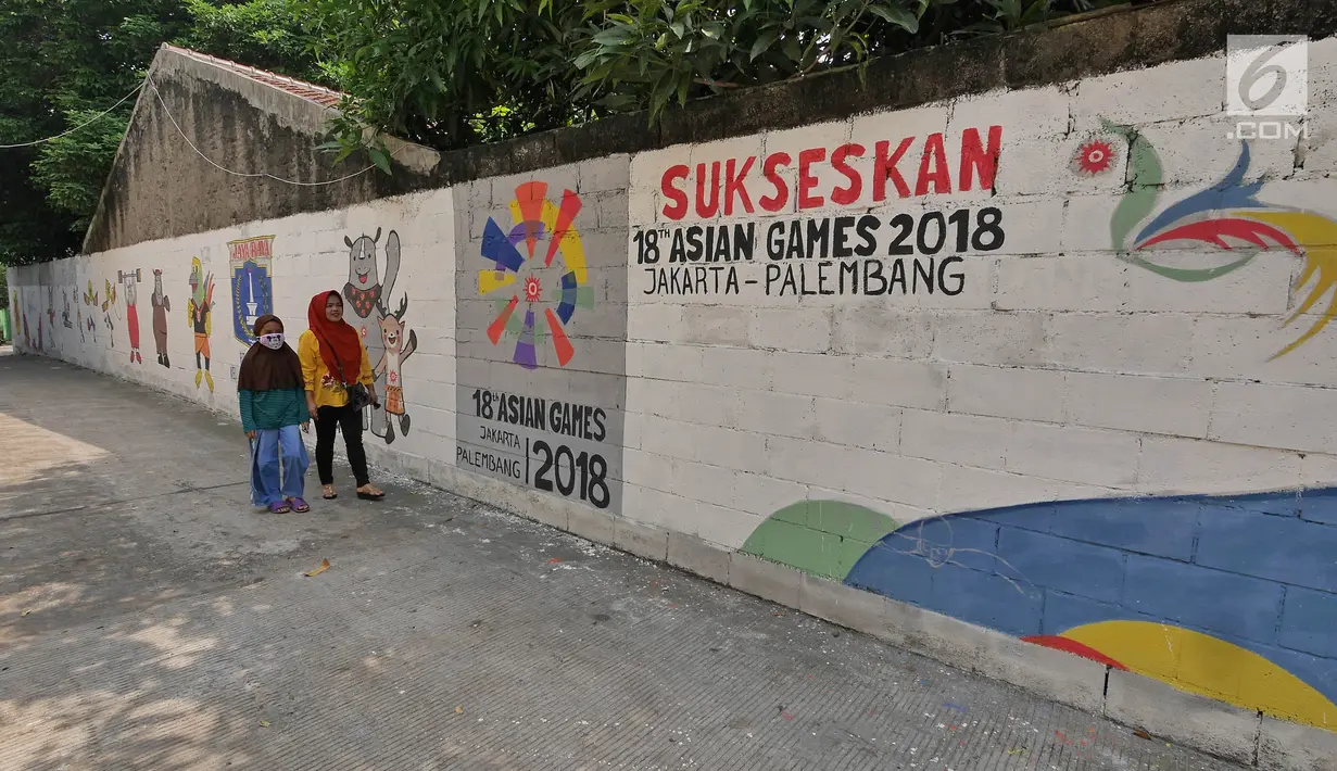 Warga berjalan di samping mural bertema Asian Games 2018 di kawasan Jati Padang Utara, Jakarta, Sabtu (12/5). (Liputan6.com/Herman Zakharia)