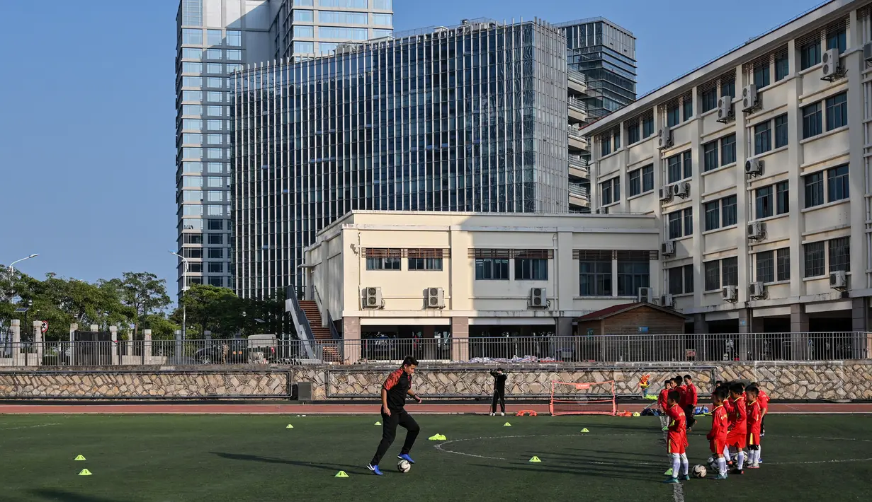 Mantan penyerang Manchester United, Dong Fangzhuo mengajarkan tehnik sepak bola kepada anak-anak saat melatih di Xiamen di provinsi Fujian, China (10/12/2019). Dong Fangzhuo yang kini berusia 34 tahun melatih anak-anak di China, beberapa di antaranya berkebutuhan khusus. (AFP/Hector Retamal)