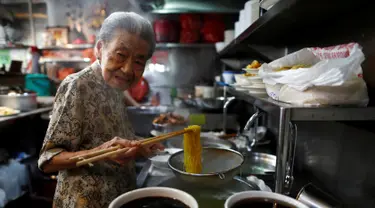 Nenek Leong Yuet Meng, pemilik usaha Nam Seng Noodle House mengolah mie di warungnya di Singapura (22/3). Leong Yuet Meng masih menjalankan usaha warung mie pangsit, meski berusia sudah menginjak 90 tahun. (Reuters/Edgar Su)