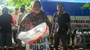Seorang warga membawa beras yang baru saja dibelinya saat operasi pasar beras oleh BULOG di Lenteng Agung, Jakarta, Senin (2/3/2015). Operasi ini digelar sebagai upaya menurunkan harga beras yang terus naik.(Liputan6.com/Yoppy Renato)