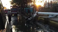Genangan air di jalan Kaligawe dipompa dan dibuang ke saluran air di selatan jalan yang mati. (foto : liputan6.com / edhie prayitno ige)